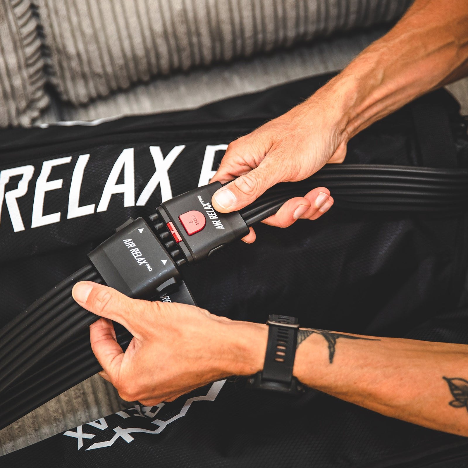 AIR RELAX PRO AR-4.0 LEG SLEEVES — Close-up of hand securing the air hose plug to leg sleeves
