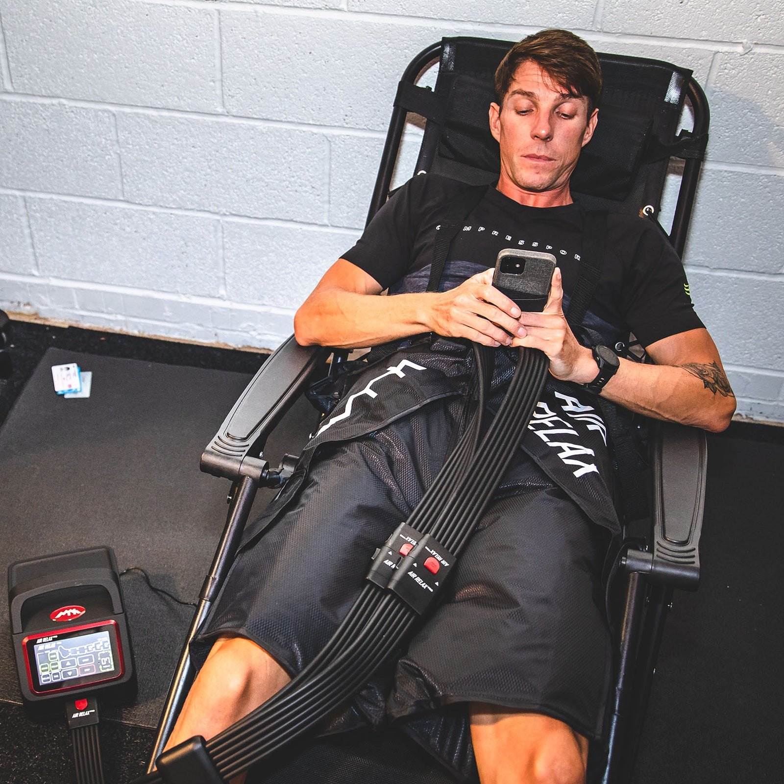 AIR RELAX PRO AR-4.0 SHORTS — Man on deckchair wearing shorts while looking at his phone